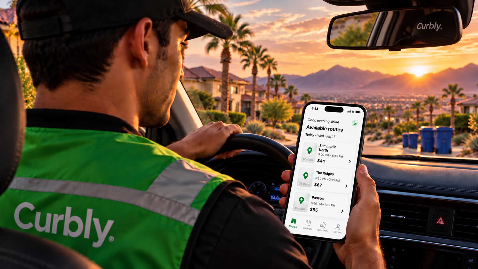 Curbly operator in the driver's seat at sunset holding an iPhone that shows available neighborhood routes with payout amounts.